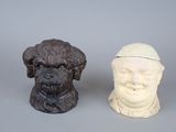 two figurines of a dog and a man with a hat