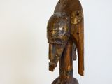 une sculpture en bois représentant un oiseau, posée sur un socle