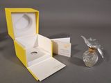 a small yellow box with a perfume bottle inside of it
