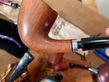 a person that is holding a pipe on a table