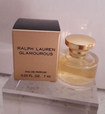 un flacon de parfum posé sur un plan de travail en marbre, à côté d'une boîte