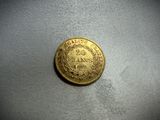 a close up of a gold coin on a white surface