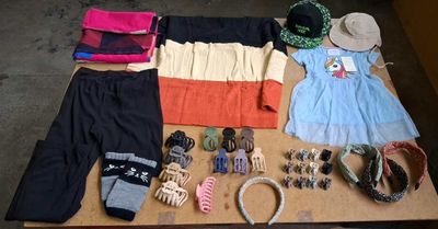 a table with a lot of clothing and accessories on it
