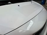 a close up of a white car parked in a parking lot