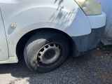 a white car with a flat tire parked on the side of the road