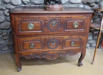 a wooden chest of drawers with a statue on top of it
