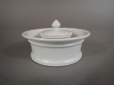 a white bowl with a lid sitting on a table