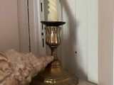 a candle and a shell on a shelf in a room