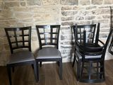 quatre chaises alignées devant un mur de briques