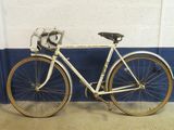 a white bicycle parked against a blue and white wall
