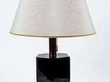 une lampe de table noire surmontée d'un abat-jour blanc