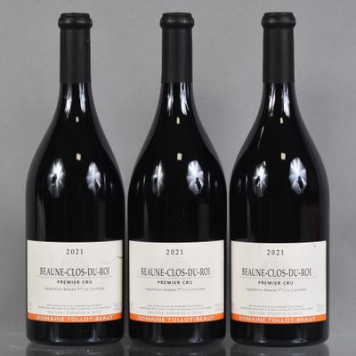 three bottles of red wine sitting on a table next to each other