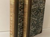 trois livres sont empilés sur une table