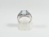 a close up of a ring with a blue topaz stone and diamonds