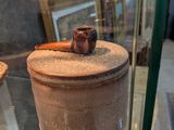une vitrine en verre sur laquelle est posé un pot