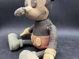 mickey mouse plush toy sitting on a black surface