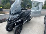 a black motorcycle parked in a parking lot next to a car