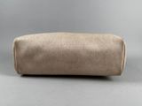 a close up of a tan toilet bag on a gray surface