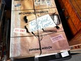 une grande boîte sur laquelle est accrochée une pancarte, posée par terre