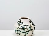 un vase blanc avec un motif sur une table