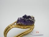 un gros plan d'une bague en or sertie d'une pierre violette