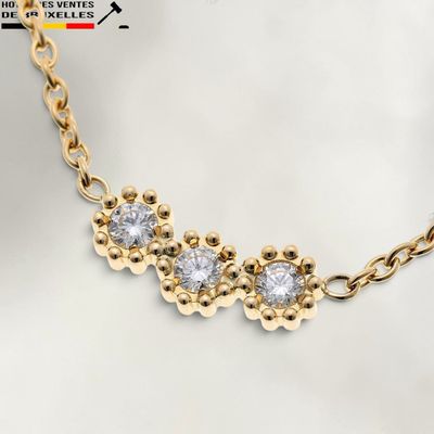 un gros plan d'un collier en or orné de trois diamants