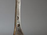 a silver spoon with a face on it on a table