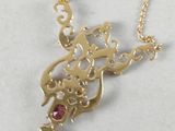 gold plated necklace with a dragon and a ruby stone