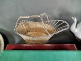 a basket with a bird on top of it on a table