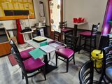 a room with a table, chairs, and a menu board on the wall