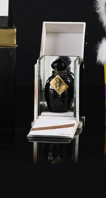 a small bottle of perfume sitting on a table next to a box