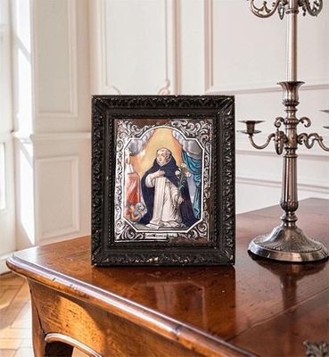 a picture of a picture of the virgin mary on a table next to a candelabra