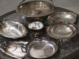 a table with a lot of silver dishes on it