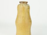 a yellow vase that is sitting on a white surface