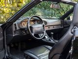 the interior of a car with the door open and the driver ' s seat down