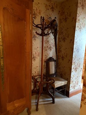 a coat rack in the corner of a room next to a chair