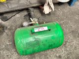 a green gas can sitting on the floor next to a shelf