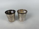 a pair of silver cups with engraved designs on them