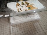 a glass table with a painting on it in front of a bike