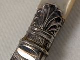 a silver spoon with a silver handle on a table