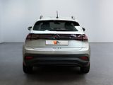 the rear end of a silver volkswagen v - cross parked in a white room