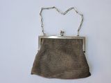 an old purse with a chain around it on a white surface