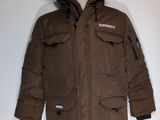 La veste est marron et possède une capuche doublée de fourrure.
