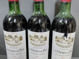trois bouteilles de vin sont alignées sur une table