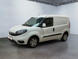 La petite camionnette blanche est garée dans une grande pièce.