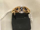 a close up of a gold ring with blue sapphires on it