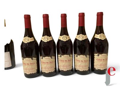 six bottles of wine are lined up in a row on a white surface