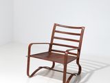 un fauteuil à bascule en bois avec une assise marron, posé sur un sol blanc