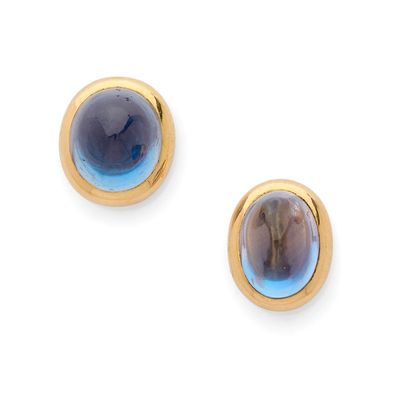 une photo d'une paire de boucles d'oreilles ornées d'une pierre bleue