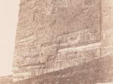 an old photo of a stone wall with a clock on it